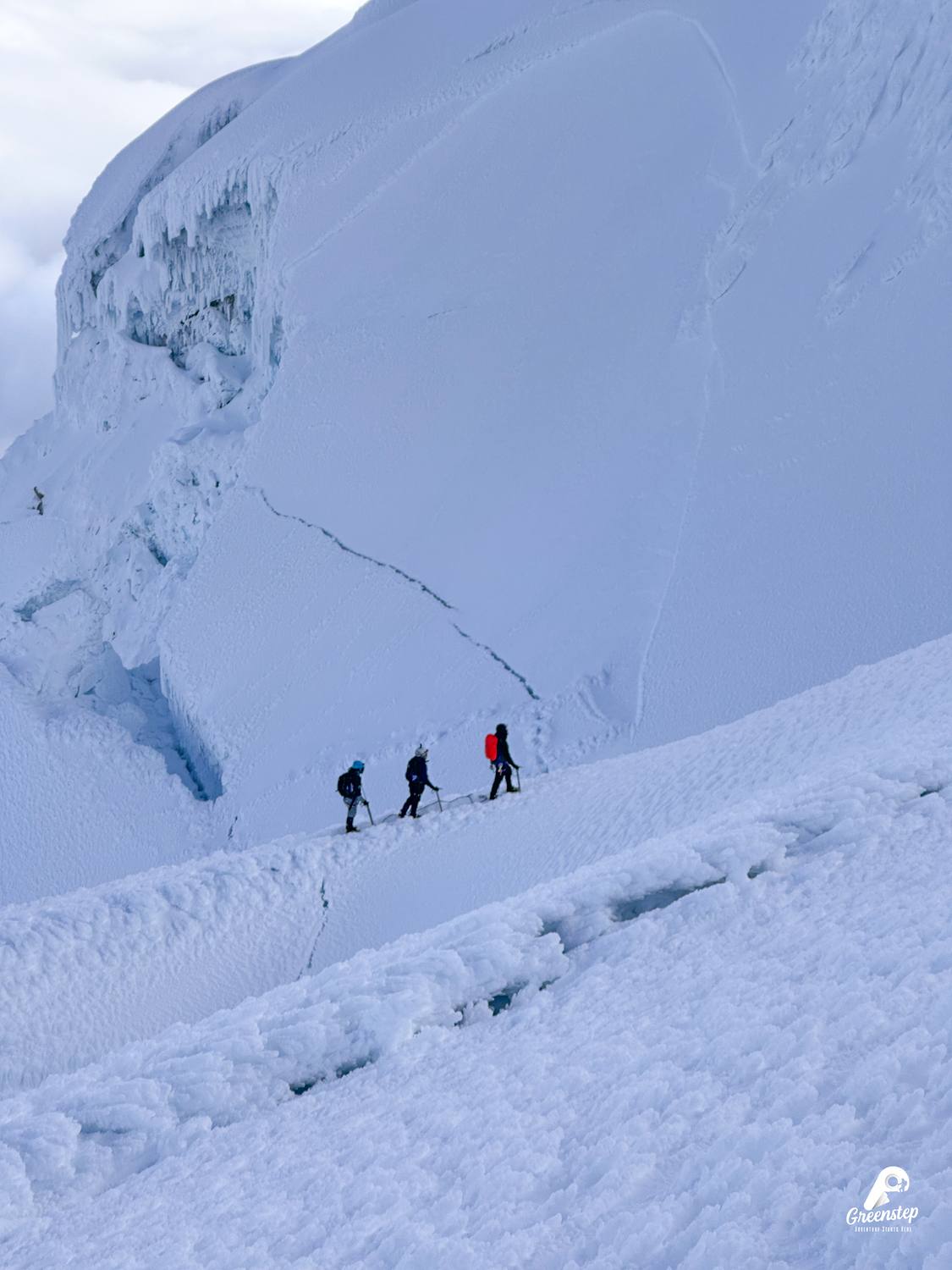 Tres montañistas encordados junto a una grieta en el Cayambe