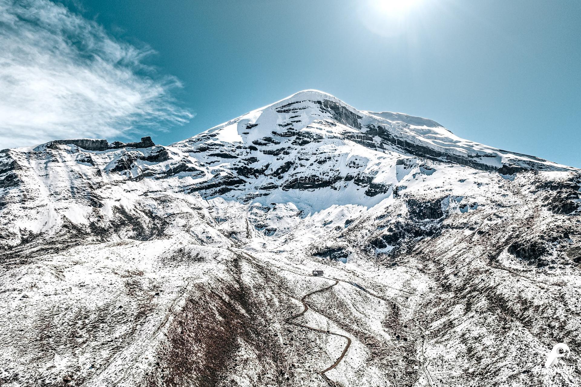 El Chimborazo nevado, con una carretera que serpentea por el páramo